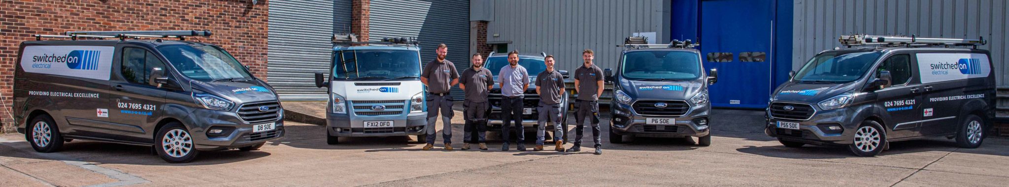 Wide-angle shot of SOE team with vans